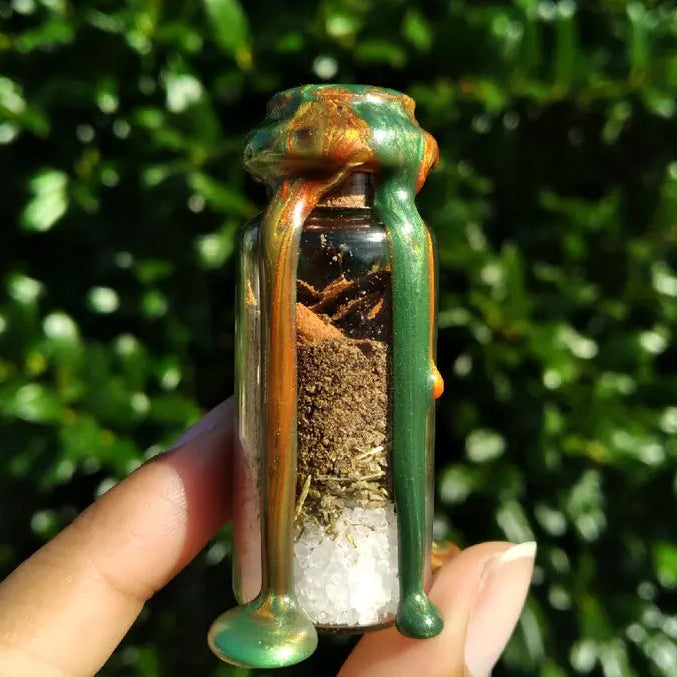 Small glass bottle with a green lid containing a small creature, held against a green leafy background.